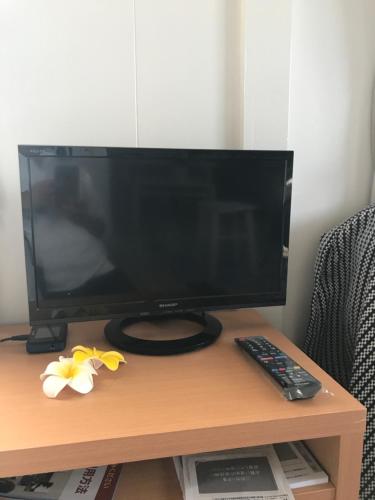 a computer monitor on a table with a remote control at Holiday Homes TSUBOYA 601 in Naha