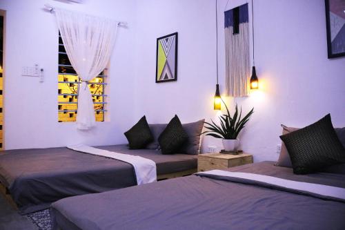 a room with two beds and a potted plant at Samstay in Tuy Hoa