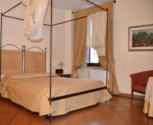 ein Schlafzimmer mit einem Himmelbett und einem Fenster in der Unterkunft Hotel Italia in Foligno