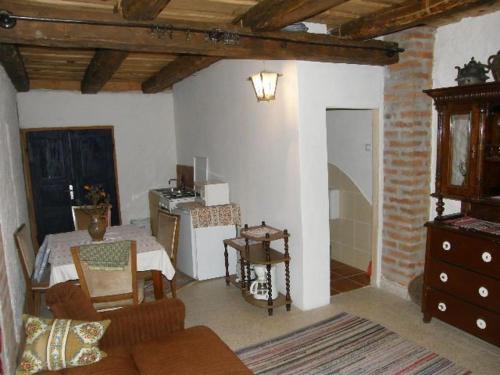 a living room with a couch and a table at Múltidéző Porta - Népi Műemlék Házak az Őrségben in Szalafő