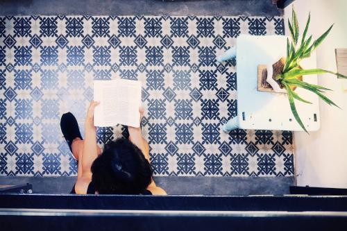 a person laying on a couch reading a book at Samstay in Tuy Hoa