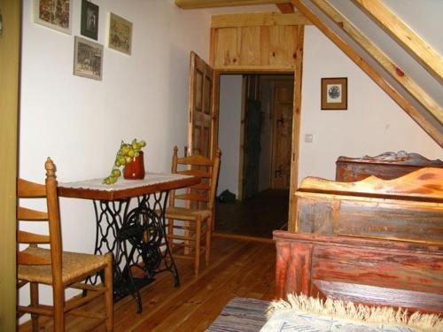 a room with a table and a bed and a desk at Múltidéző Porta - Népi Műemlék Házak az Őrségben in Szalafő