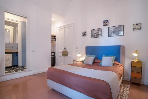 a bedroom with a large bed with a blue headboard at Napoliamo Guest House in Naples