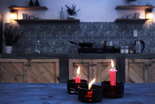 three candles sitting on a table in a kitchen at Samstay in Tuy Hoa