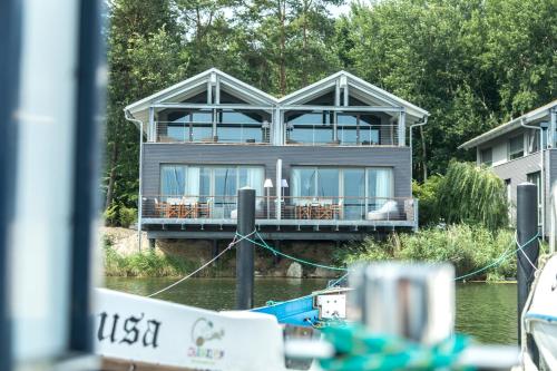 a house on the water with a boat in front of it at Im-Jaich Naturoase Gustow in Gustow