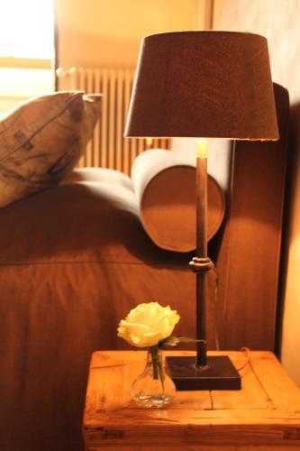 a lamp on a table with a flower on it at B&B Hof te Spieringen in Vollezele