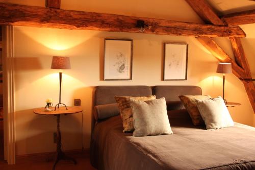 a bedroom with a bed with pillows and a table at B&B Hof te Spieringen in Vollezele