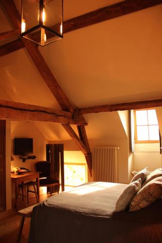 a bedroom with a bed and a desk in a room at B&B Hof te Spieringen in Vollezele