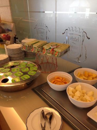 a buffet with bowls of food and plates and spoons at Hotel Suave Mar in Esposende