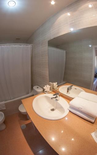 a bathroom with a sink and a toilet and a tub at Apartahotel Aguadulce in Aguadulce