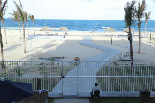a view of a beach with palm trees and the ocean at Apart Porto das Dunas in Aquiraz