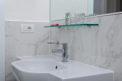 a white bathroom with a sink and a mirror at Hotel Universal Terme in Abano Terme