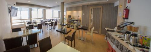 Un restaurante con mesas y sillas y un mostrador. en Apartahotel Aguadulce, en Aguadulce
