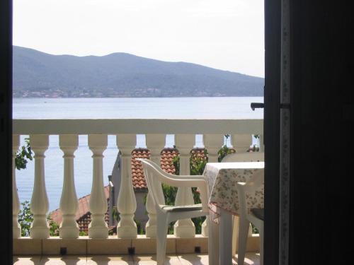 a table and chairs on a balcony with a view of the water at Apartments Brčić in Sveti Petar