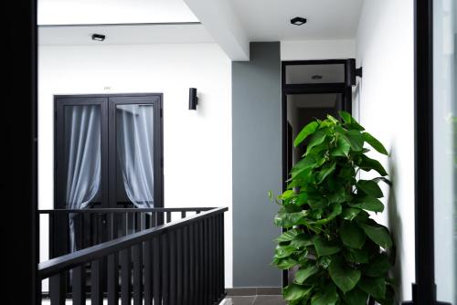 a plant sitting on a balcony next to a black door at La Me Villa Hoi An in Hoi An