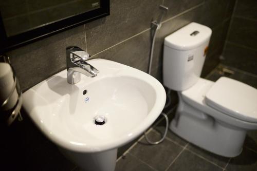 ein Badezimmer mit einem weißen Waschbecken und einem WC in der Unterkunft La Me Villa Hoi An in Hoi An
