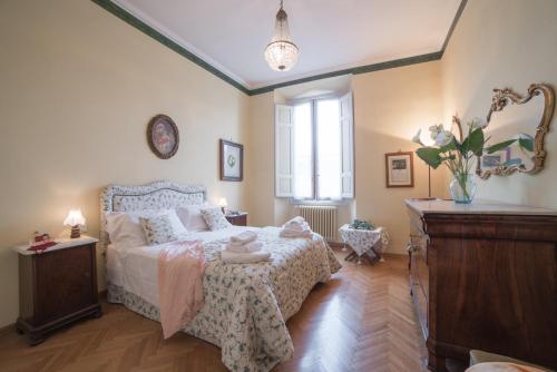 フィレンツェにあるFirenze Duomo Suiteのベッドルーム1室(ベッド1台、ドレッサー、窓付)