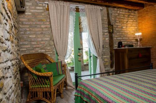 Le Voltarelle Bed & Breakfast في Serra San Quirico: غرفة نوم بسرير وكرسي ونافذة