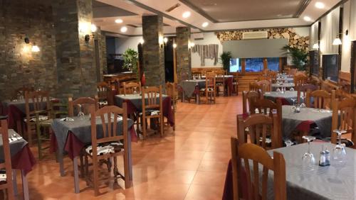 Cúllar de BazaにあるHostal Venta del Peralのレストラン内のダイニングルーム(テーブル、椅子付)