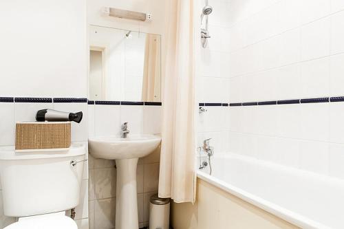 ロンドンにあるTrendy Central Apartmentのバスルーム(洗面台、トイレ、バスタブ付)