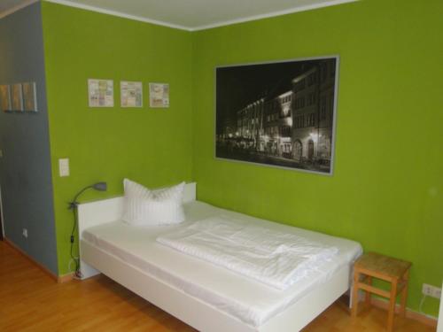 una camera verde con un letto con una foto sul muro di Cityappartment am Stadttheater a Friburgo in Brisgovia