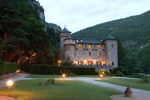 a large castle with lights in the yard at Chateau De La Caze in Sainte-Énimie