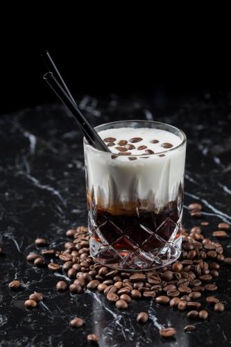 a drink in a glass sitting on a pile of coffee beans at Wyndham Stuttgart Airport Messe in Stuttgart