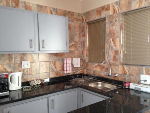 a kitchen with a sink and a counter top at Impala Chalets in Phalaborwa