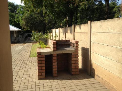 a bench made out of bricks next to a fence at Impala Chalets in Phalaborwa