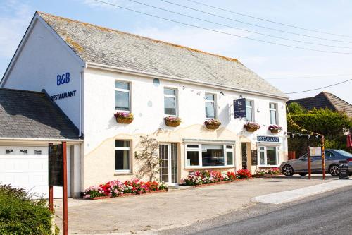 a white building with flowers in front of it at The White Heron in Polzeath