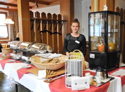 a woman standing in front of a table with food at Hotel Hasen Kaufbeuren Allgäu in Kaufbeuren
