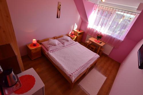 a small bedroom with a bed and a window at Penzión Family Rušin in Veľká Lomnica