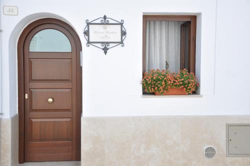 a door on a building with a window and a flower pot at Al Borgo Antico Ristorante e B&B in Crispiano