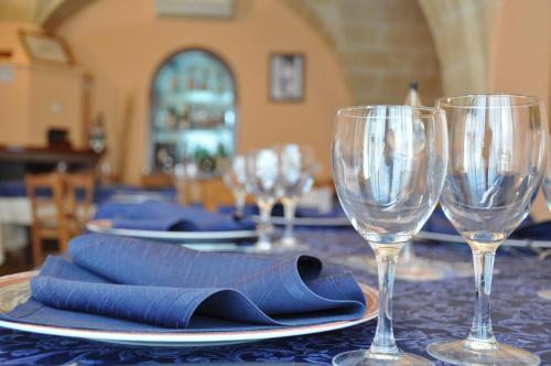 a table with two wine glasses and a blue napkin at Al Borgo Antico Ristorante e B&B in Crispiano