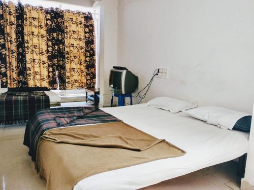 Postel nebo postele na pokoji v ubytování Hotel Ashwini Lodge