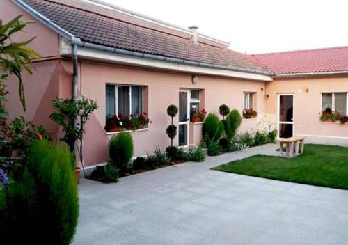 a house with a courtyard with a bench in front of it at Pensiunea Gheorghita in Haţeg