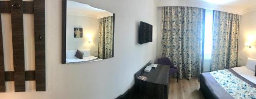 a hotel room with a mirror and a bed at Non-stop hotel in Boryspilʼ