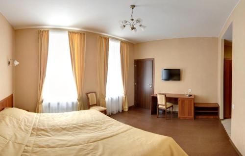 a bedroom with a bed and a desk with a television at Aximaris furnished rooms in Saint Petersburg