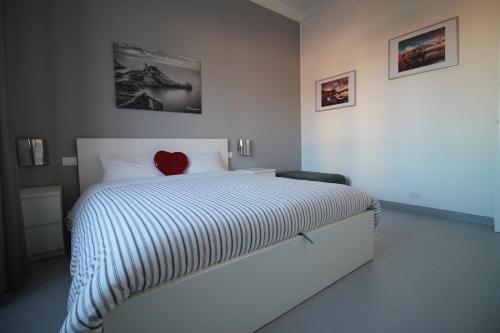 Un dormitorio con una cama con un corazón rojo. en Interno24 Apartment en La Spezia