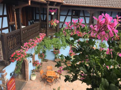 a balcony of a house with pink flowers at Hotel Kieffer in Itterswiller