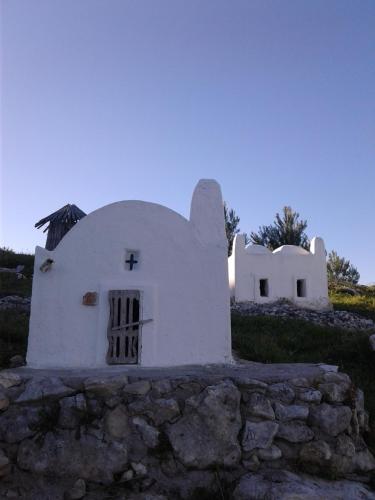 a small white church on a hill with a stone wall at GRANELLO di Sabbia in Peschici