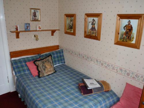 a small bedroom with a bed with a book on it at Ferintosh Guest House in Dumfries