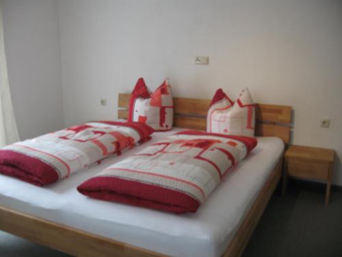 ガシュルンにあるFerienwohnung Nicoleのベッド(赤と白の枕4つ付)