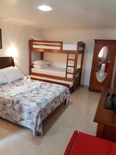 1 dormitorio con 2 literas y espejo en Pousada Princesa, en Arraial do Cabo