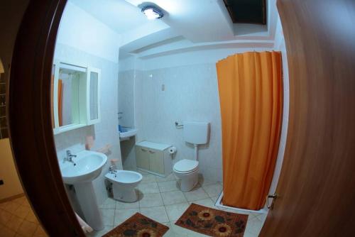 bagno con tenda doccia arancione e servizi igienici di Villa Calidea a Bova Marina