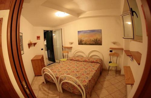una piccola camera con un letto in una stanza di Villa Calidea a Bova Marina