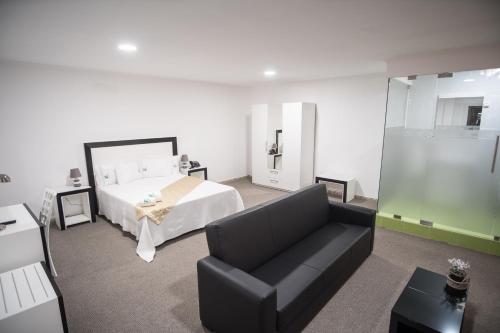 ein Wohnzimmer mit einem Bett und einer Couch in der Unterkunft SH Boutique Hotel in São Tomé