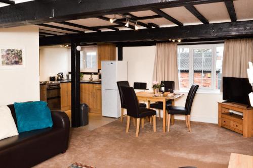 a living room with a table and chairs and a kitchen at Wrenbury Mill Apartment in Wrenbury
