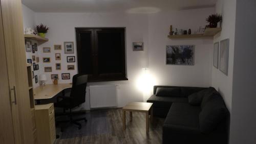 a living room with a couch and a table and a desk at Walbrzych - przytulne, nowe mieszkanie in Wałbrzych