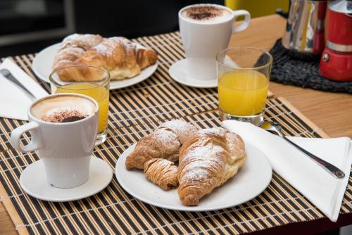 a table with two cups of coffee and croissants at Napoliamo Guest House in Naples